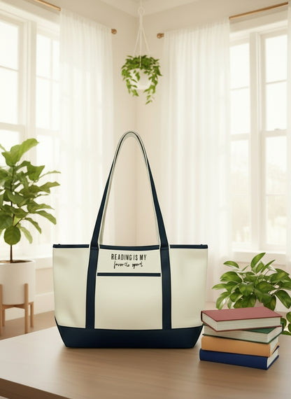 reading themed canvas tote bag with navy accents on a table with books and plants