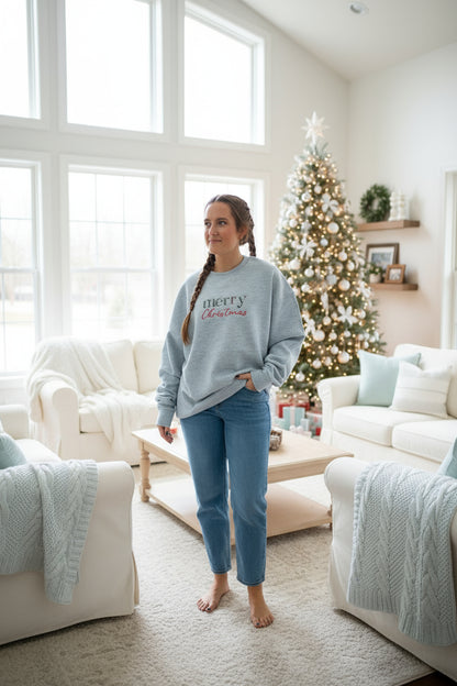 Person wearing a gray sweatshirt with 'Merry Christmas' EMBROIDERED text, standing against a LIGHT background.